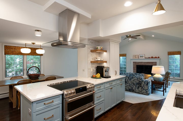 Refreshed kitchen in Evanston, Illinois with wood floors, modern finishes and beautiful white counter tops, with wooden corner shelves and thoughtful lighting throughout.