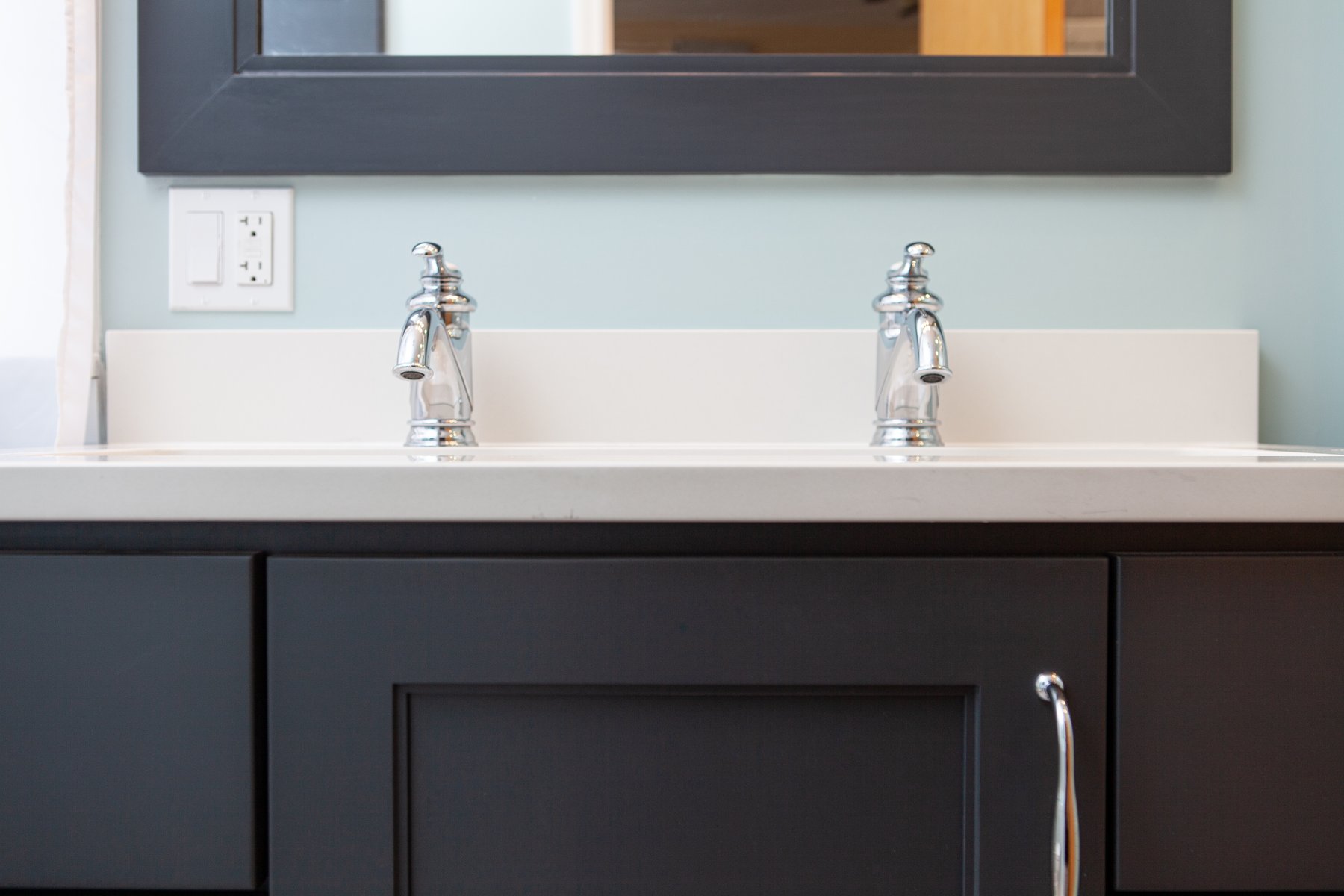 small bathroom remodel with black cabinets and chrome hardware with a double-sink and painted floor heater