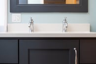 small bathroom remodel with black cabinets and chrome hardware with a double-sink and painted floor heater