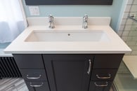 small bathroom remodel with black cabinets and chrome hardware with a double-sink and painted floor heater
