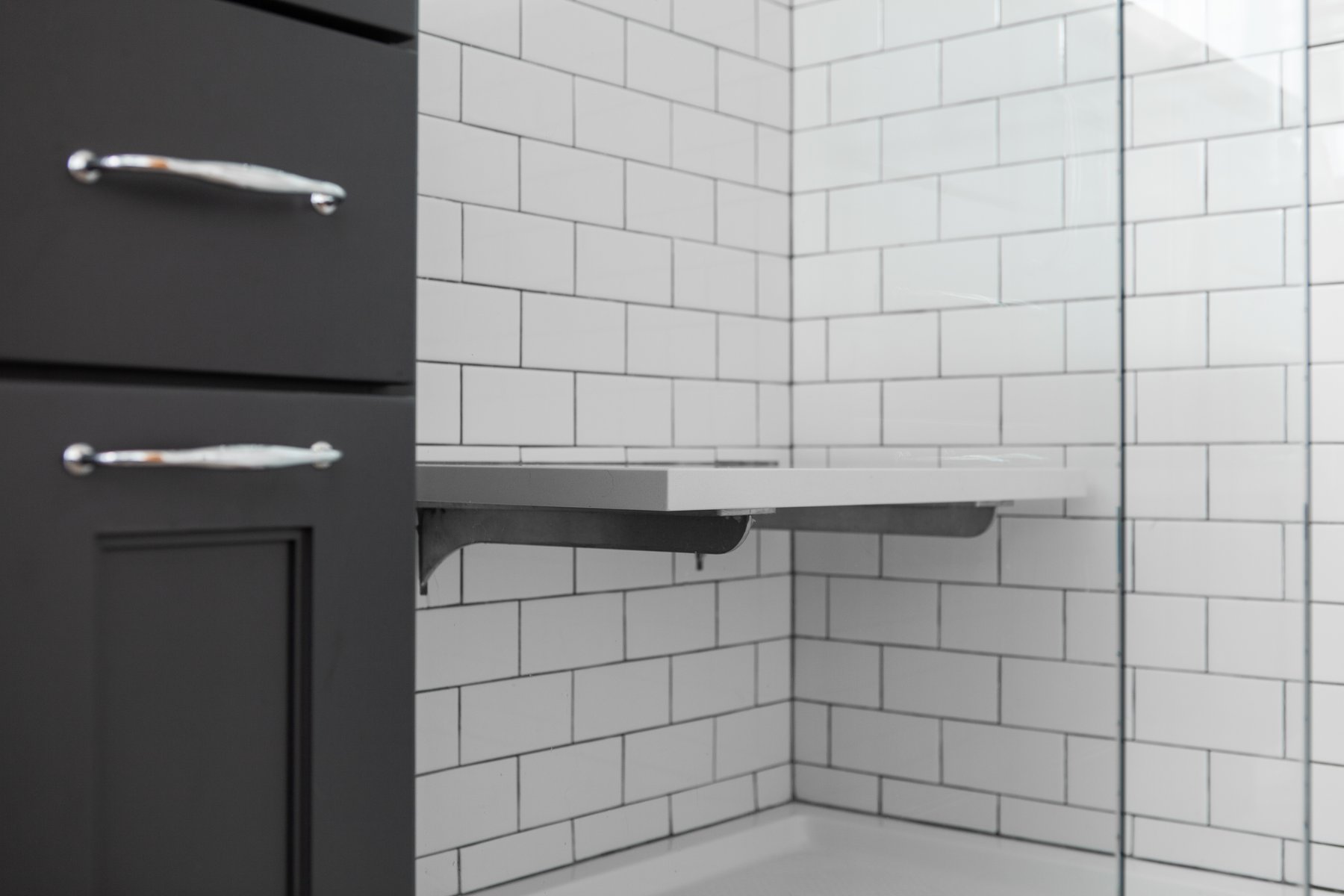 Classic white subway tile make a small bathroom feel larger and compliments the black cabinetry