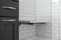 Classic white subway tile make a small bathroom feel larger and compliments the black cabinetry