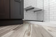 Painted black cabinetry contrasting beautiful hardwood floors and the simplicity of white subway shower tiles
