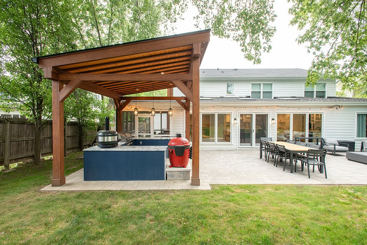 Remodeled backyard in Lake Forest, Illinois with a covered patio, outdoor kitchen area, and an outdoor living area.