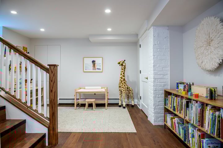 Basement with white walls and wood floors.