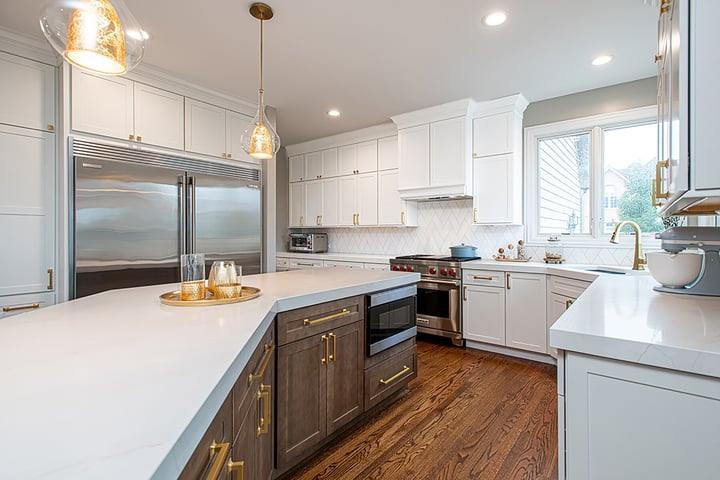 Remodeled kitchen with white counter tops, white cabinets and wood floors.