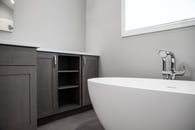 Beautiful modern bathroom remodel in Lake Zurich with natural gray cabinets, chrome finishes and white tub.
