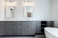 Beautiful modern bathroom remodel in Lake Zurich with natural gray cabinets, chrome finishes and white tub.