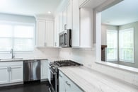 Beautiful modern kitchen remodel in Lake Zurich with natural wood floors and white cabinets.