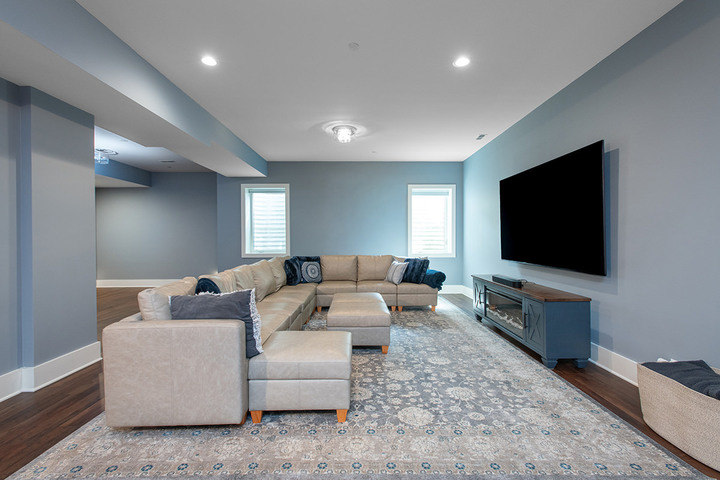 Renovated basement in Libertyville, Illinois with light blue walls, natural sunlight, wood flooring and an overall updated feel.