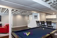 Remodeled basement in Libertyville, Illinois with hardwood floors, pool table, workout room and lounge area.