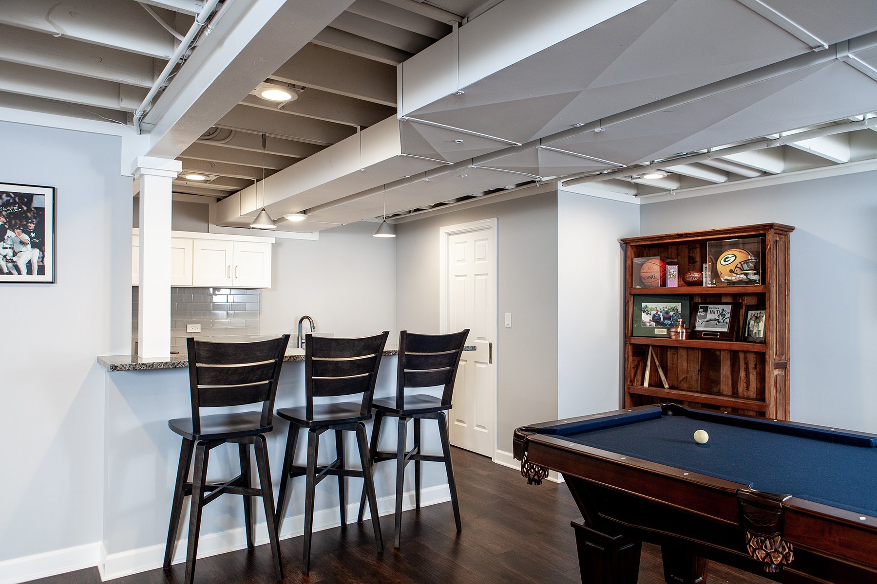 Remodeled basement in Libertyville, Illinois with hardwood floors, pool table, workout room and small kitchen.