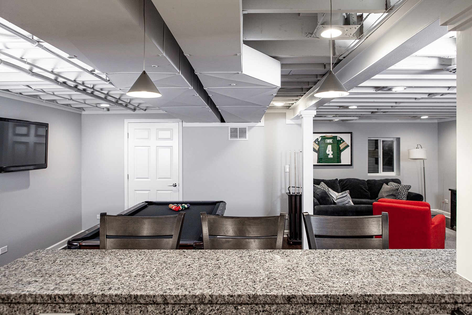 Remodeled basement in Libertyville, Illinois with hardwood floors, pool table, workout room, lounge area and kitchen.