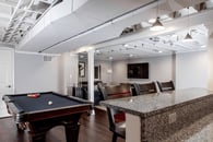 Remodeled basement in Libertyville, Illinois with hardwood floors, pool table, workout room, lounge area and kitchen.