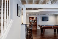 Remodeled basement in Libertyville, Illinois with hardwood floors, pool table, workout room, lounge area and kitchen.