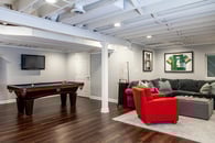 Remodeled basement in Libertyville, Illinois with hardwood floors, pool table, workout room, lounge area and kitchen.