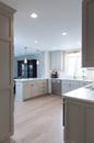 Kitchen renovation with gray painted cabinets, gold hardware, white marble countertops and a backsplash with white subway tile.