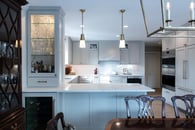 Kitchen renovation with gray painted cabinets, gold hardware, white marble countertops and a backsplash with white subway tile.