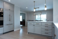 Kitchen renovation with gray painted cabinets, gold hardware, white marble countertops and a backsplash with white subway tile.