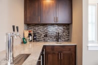 Bonus room remodel with bar nook complete with kegerator and wooden cabinetry.