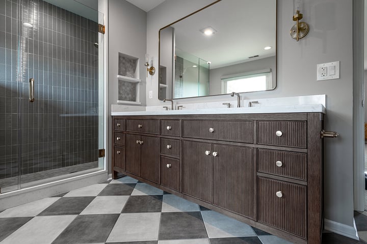 Renovated bathroom with checkered tile flooring, wooden vanity and satin finishes.