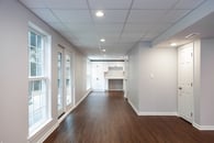 Remodeled basement in Lake Bluff, Illinois with white cabinetry, hardwood flooring, light gray wall paint and lots of windows throughout.