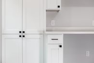 Remodeled basement with custom white cabinetry and light gray wall paint.