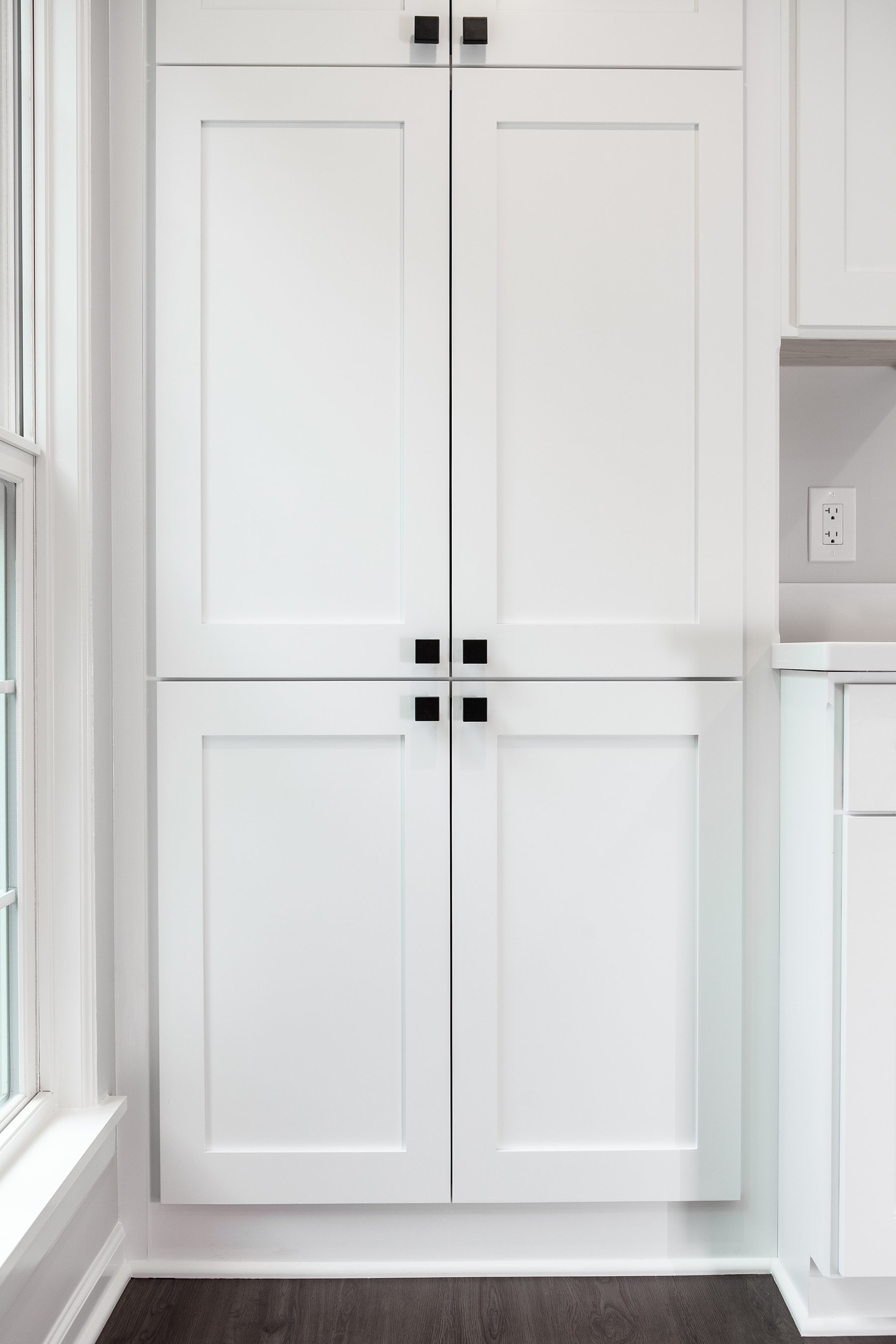 Remodeled basement with custom white cabinetry and light gray wall paint.
