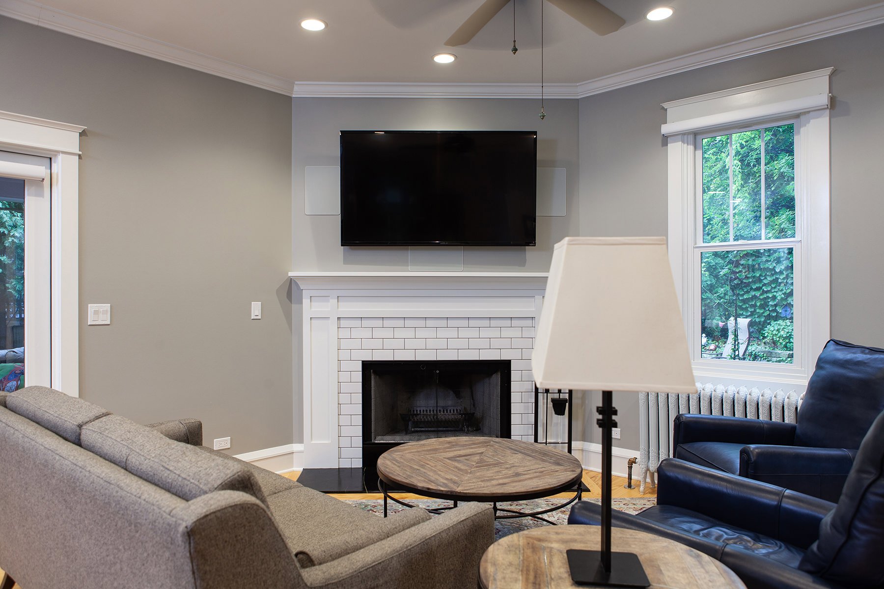 Medium gray walls, subway tiled fireplace and light wood flooring make for a classic, yet, modern look in this Libertyville home remodel.