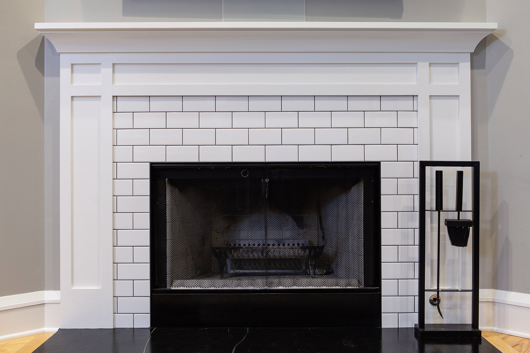 Subway tiled fireplace surround and custom white trim mantle..
