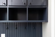 Navy mudroom cabinetry with lots of storage.