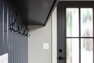 Navy mudroom trim with a beautiful classic black door.