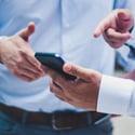 two men discussing the contents on a mobile phone