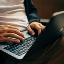 Man sitting typing on a laptop.