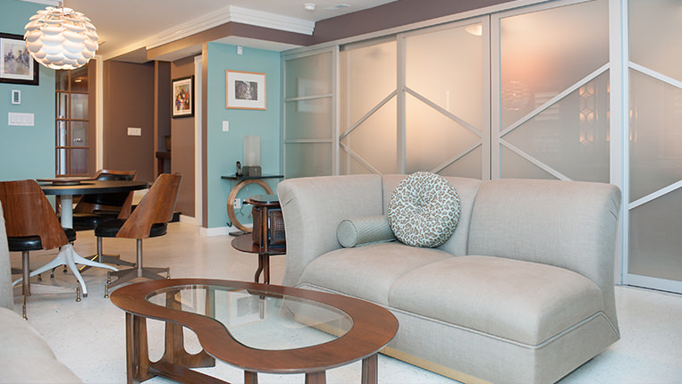 Contemporary home office with couch, coffee table, small conference table and fogged glass dividers.