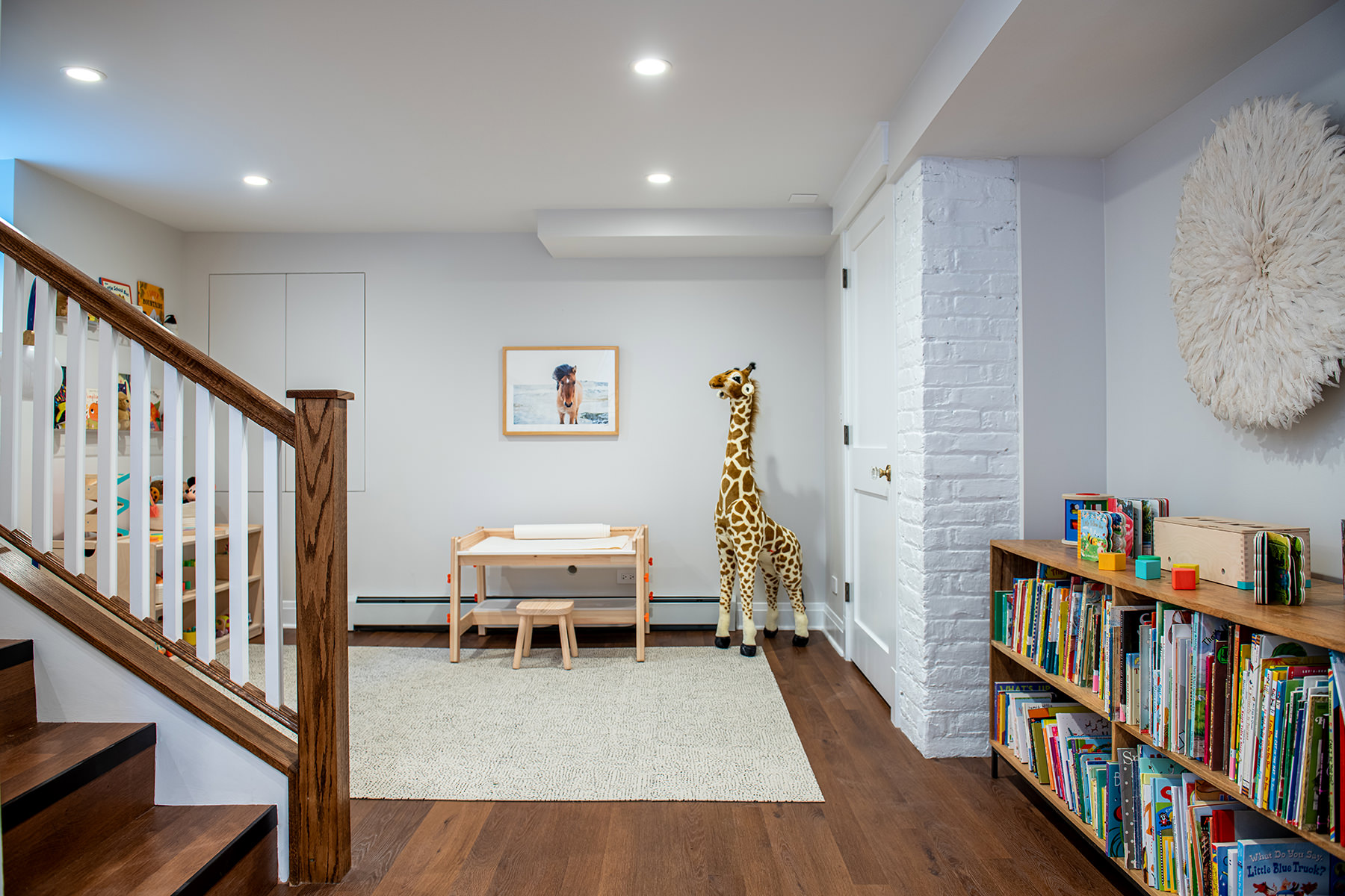 Basement with white walls and wood floors.