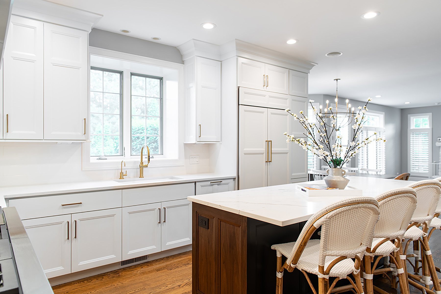 Open kitchen remodel with white cabinets, natual wood kitchen island with champagne bronze hardware throughout.