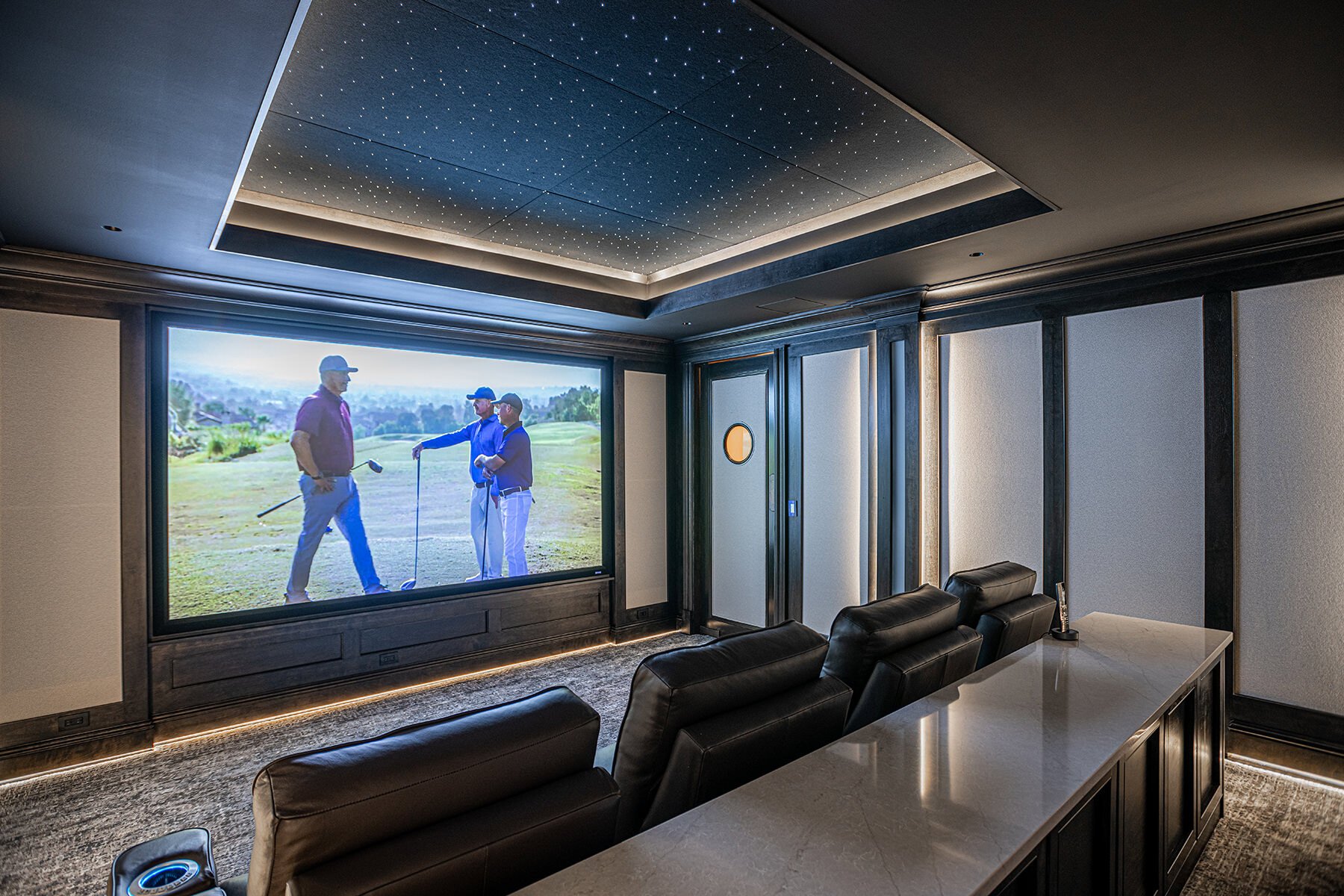 Home theater with leather chairs large theater screen and led lights on the ceiling