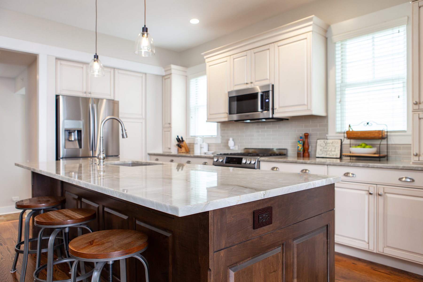 Remodeled kitchen in Libertyville with white cabinets, stainless steel appliances and a dark wood kitchen island.