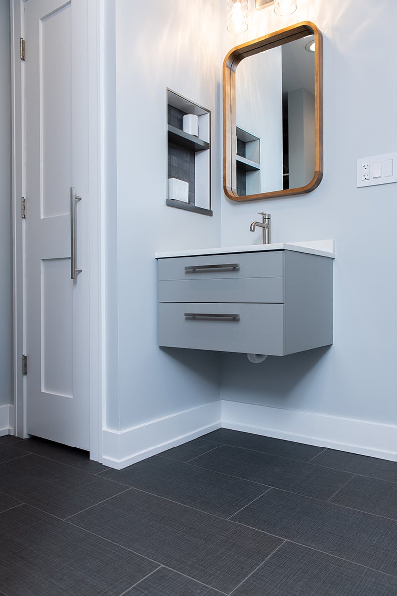 modern gray bathroom vanity raised for accessibility with polished nickel hardware and wooden framed mirror