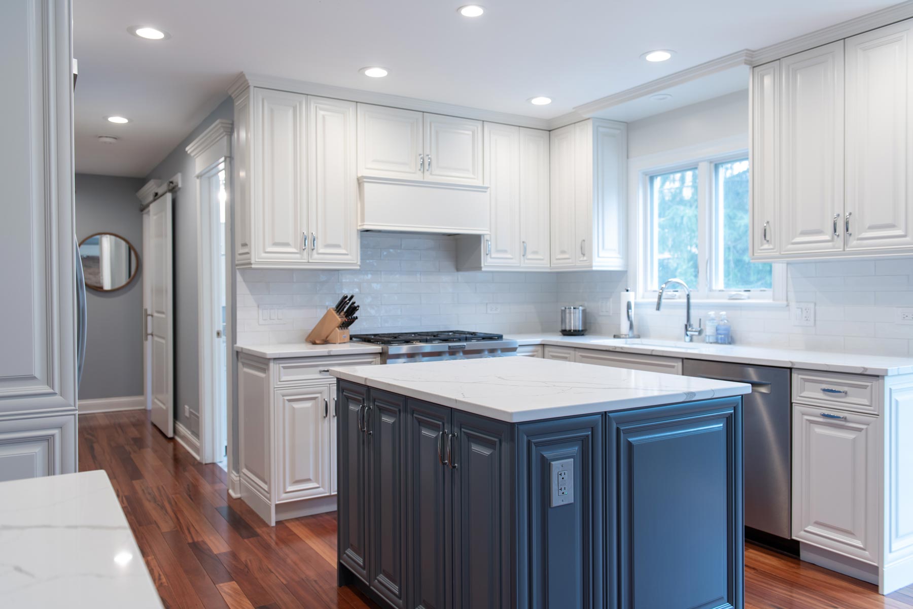 Repainted white kitchen cabinets with a navy blue painted island.